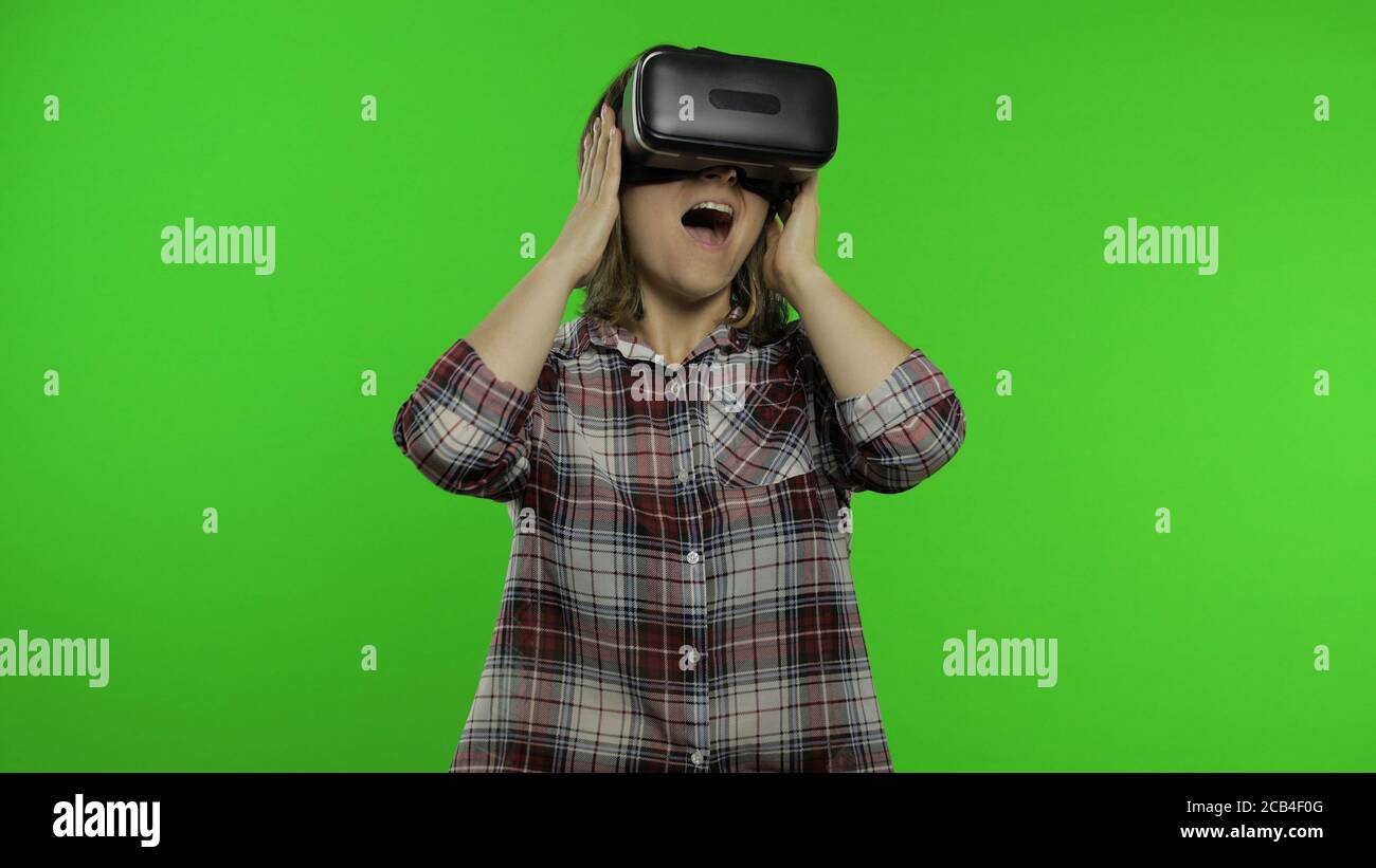 Junge Frau setzen auf VR-App Headset Helm Simulation gruseliges Spiel zu spielen. Virtual Reality 3D 360 Horrible Video ansehen. Isoliert auf Chroma-Key-Hintergrund. Mädchen in VR-Brille Angst, verängstigt Stockfoto