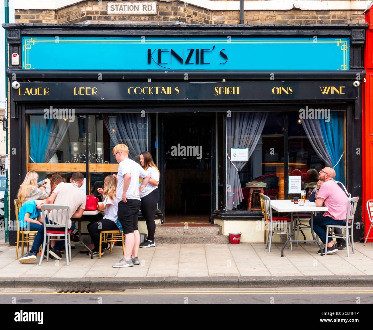 Gäste genießen die Sommersonne im Freien vor der Kenzies Café Bar Station Road Redcar Cleveland North Yorkshire Stockfoto