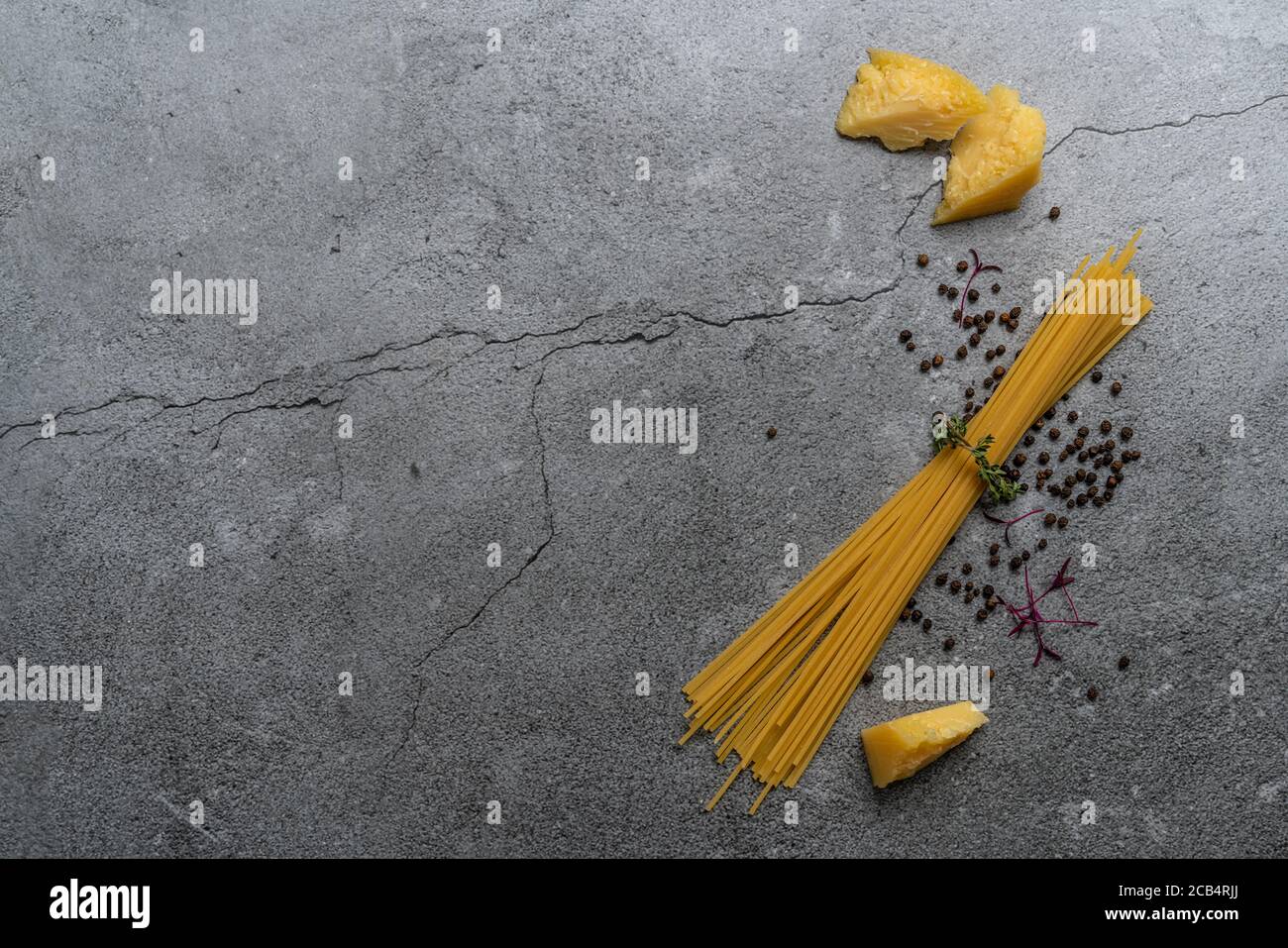 Gelbe Pasta auf grauem Hintergrund. Spaghetti auf Zement Hintergrund. Rohe Spaghetti Bolognese. Food Background Konzept. Draufsicht Stockfoto