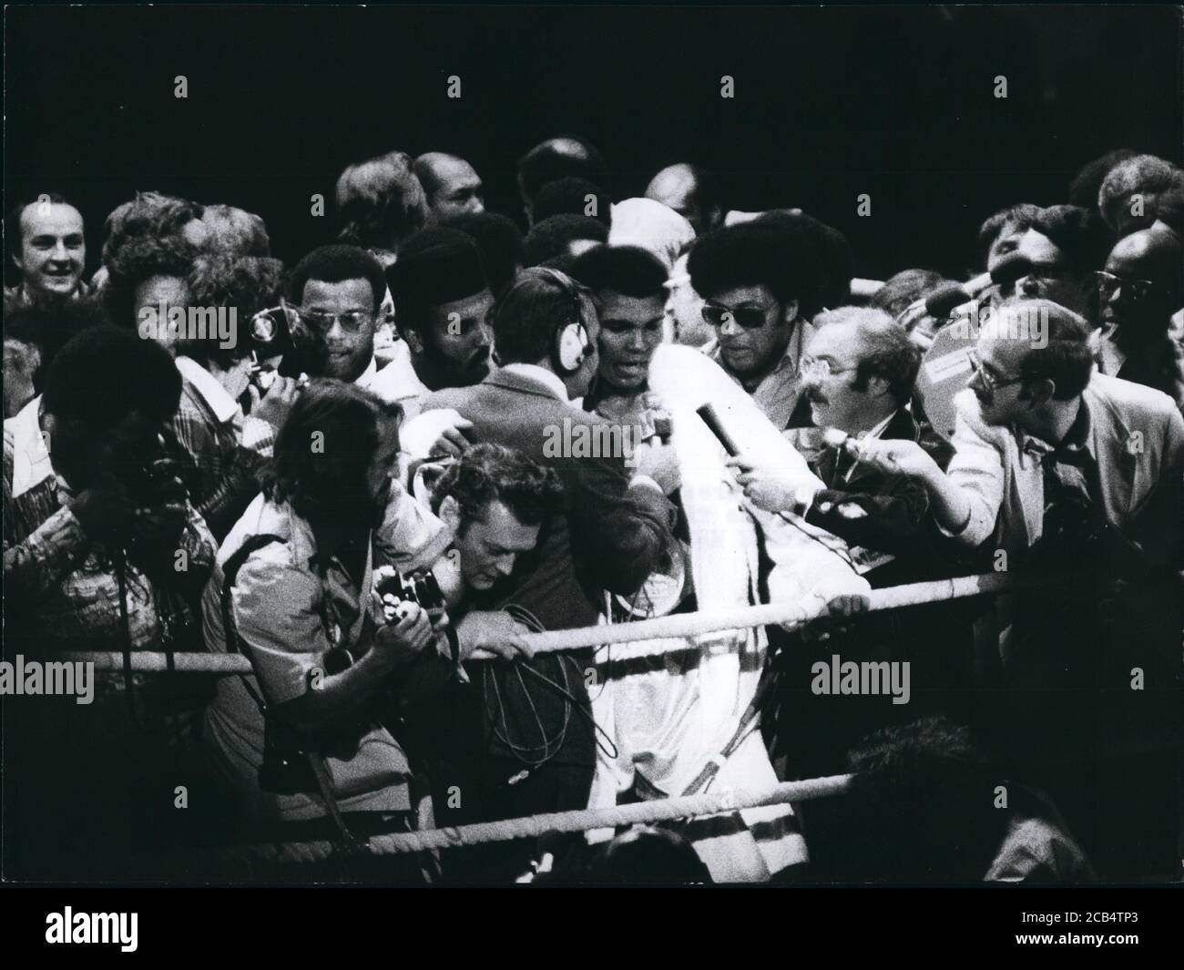 25. Mai 1976 - München, Deutschland - MUHAMMAD ALI ist immer noch der Größte. Der amerikanische Schwergewichtsweltmeister verteidigte seinen Titel vor 10.000 Zuschauern erfolgreich gegen den Europameister R. Dunn in der Münchner Olympiahalle. Ali besiegte Dunn mit technischem KO im fünften. Der britische Herausforderer war in der fünften Runde nach einem interessanten Kampf, in dem er mehrere Knock-Downs gemacht hatte, an die Ecke geschickt worden. Ali erhielt 1, 65 Millionen Dollar für seinen Sieg, während Dunn 100 000 Dollar bekam. Ali ist nach dem Kampf von Journalisten umgeben. (Bild: © Keystone Pictures USA/ZUMAPRESS.com) Stockfoto