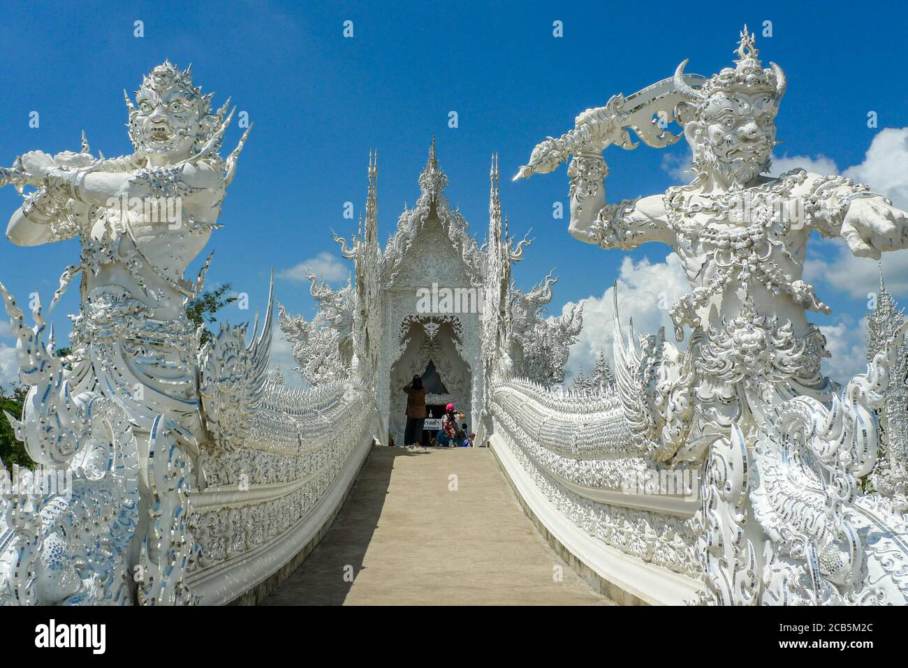 Wat Rong Khun (Weißer Tempel), Chiang Rai, Thailand. Furchteinflößende Wächter stehen neben dem Eingang zur Haupthalle. Stockfoto