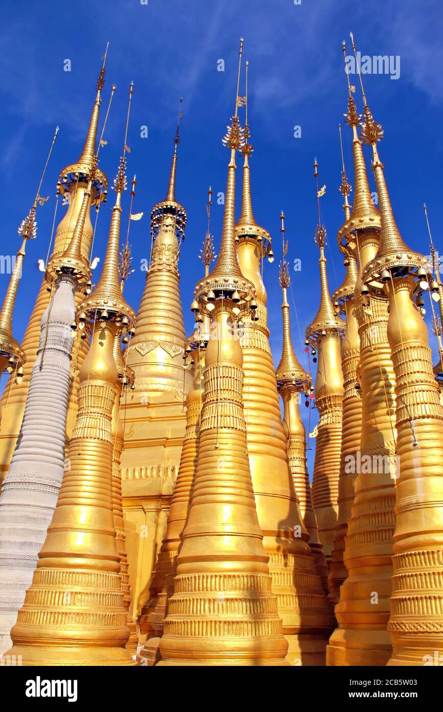 Goldene buddhistische Stupas mit Glocken auf dem Hintergrund des blauen Himmels mit Wolken bei Shwe Indein, Inle Seengebiet in Myanmar Stockfoto