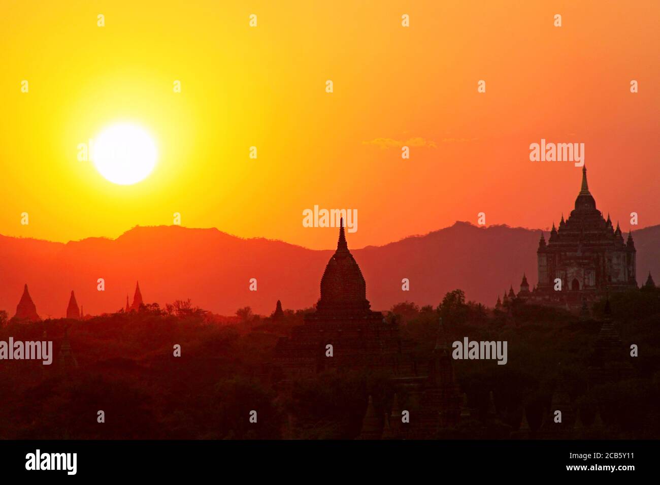 Silhouetten alter buddhistischer Pagoden auf dem Hintergrund des Sonnenuntergangshimmels in Old Bagan, Myanmar Stockfoto