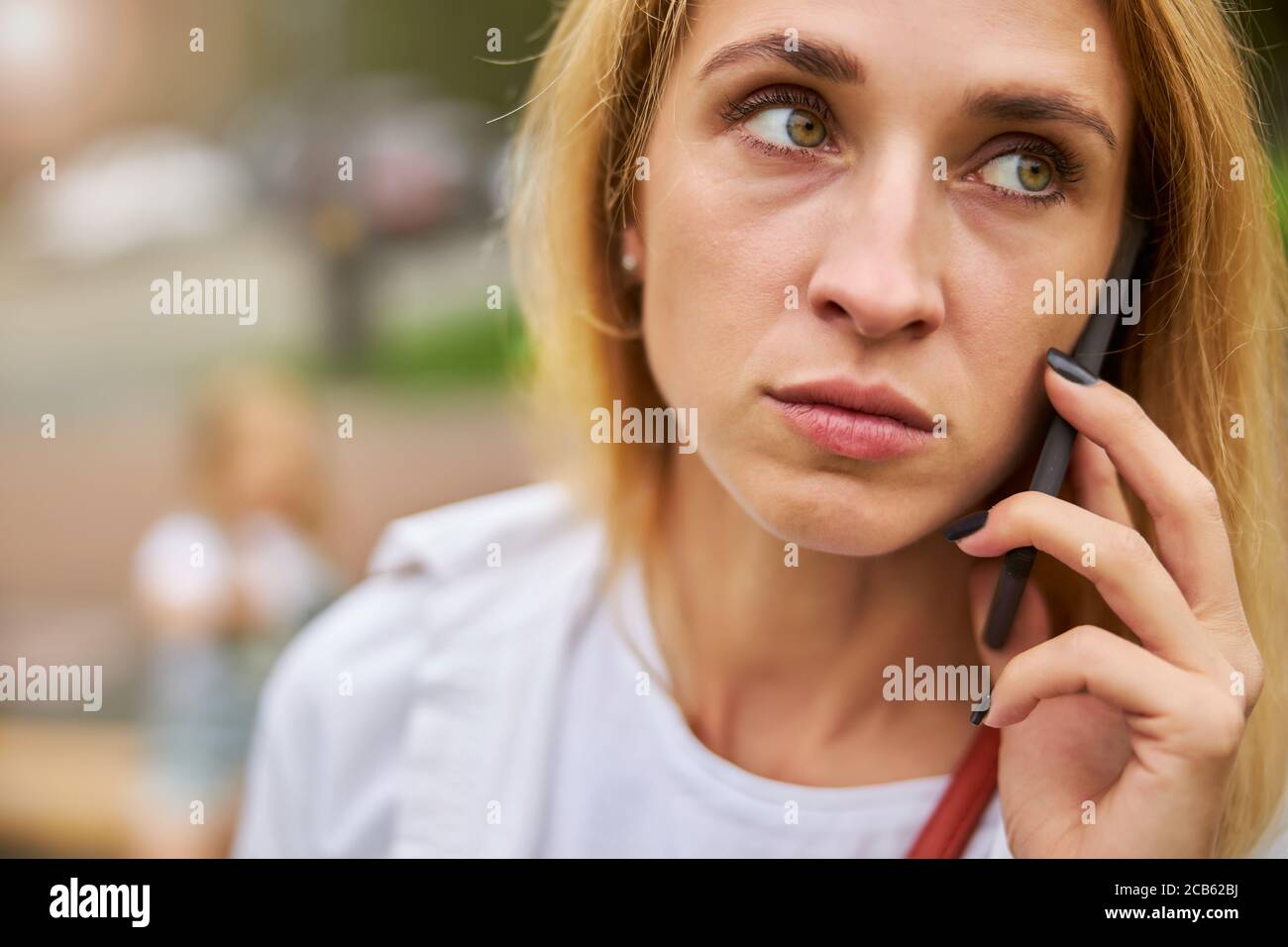 Weibliche Gefühl verwirrt, während Nachrichten von Anruf hören Stockfoto