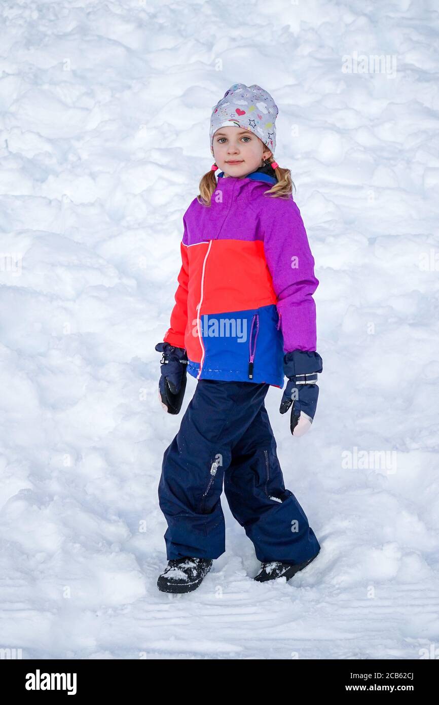 Outdoor Winter Porträt von kleinen niedlichen Mädchen tragen Ski-Kleidung.  Mädchen im Schnee zu Fuß. Stylische Kleidung für Kinder Stockfotografie -  Alamy