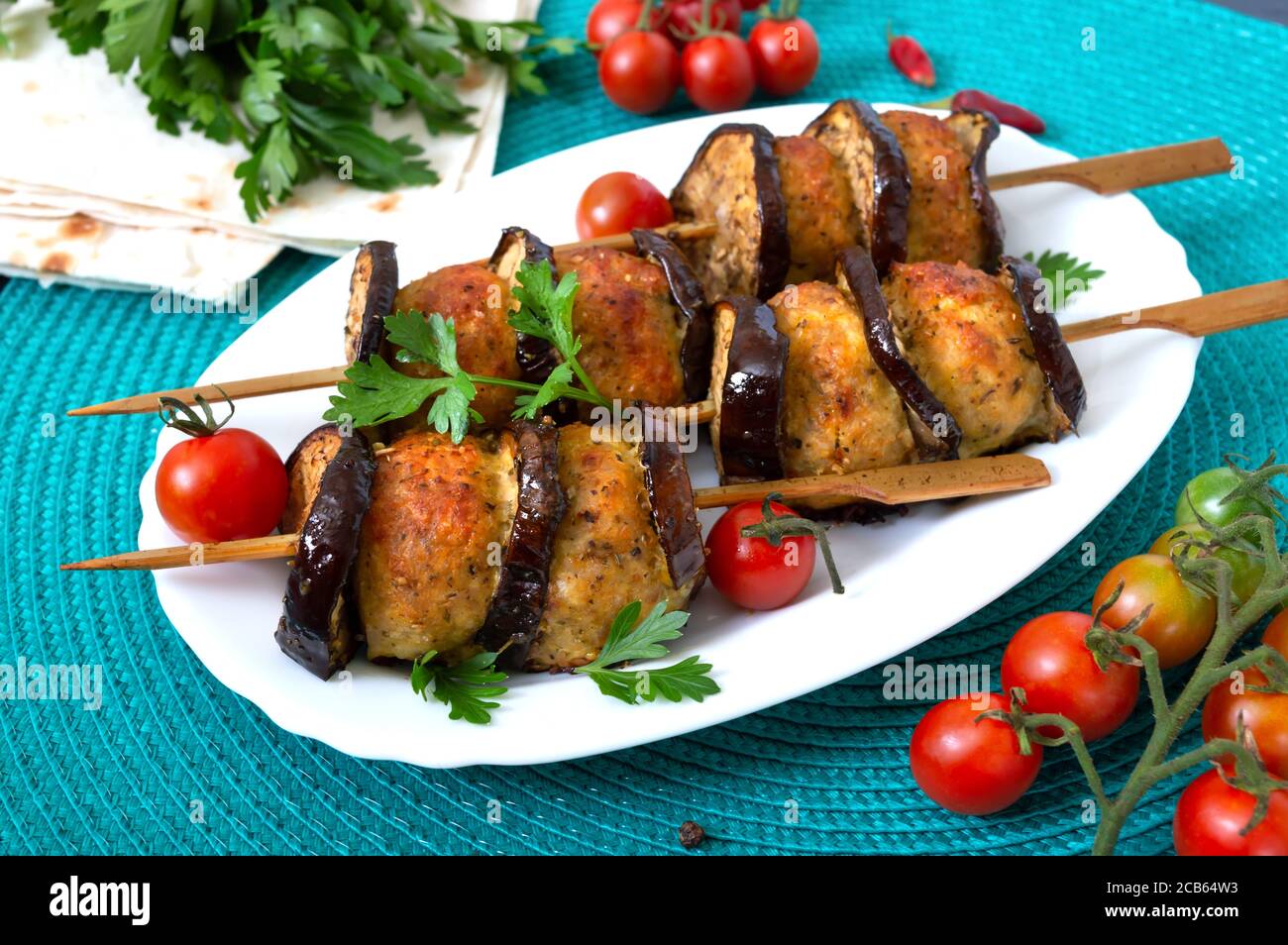 Geriebenen Fleischbällchen mit Auberginen auf Spieße. Hühnerkebab mit Gemüse. Diät-Fleischgericht. Stockfoto