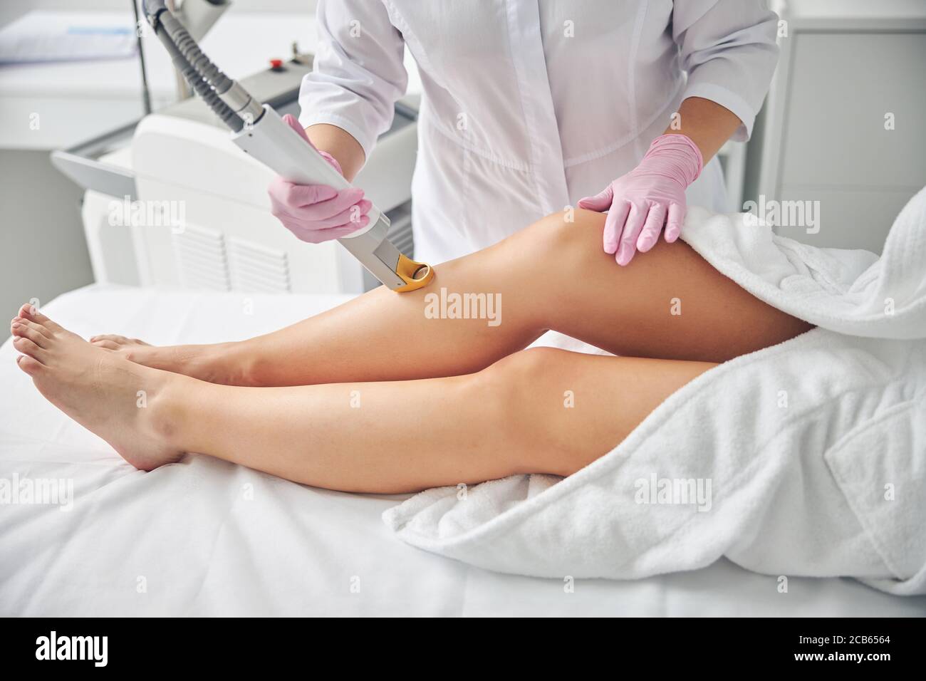 Dermatologe entfernt unerwünschte Haare auf weiblichen Beinen Stockfoto