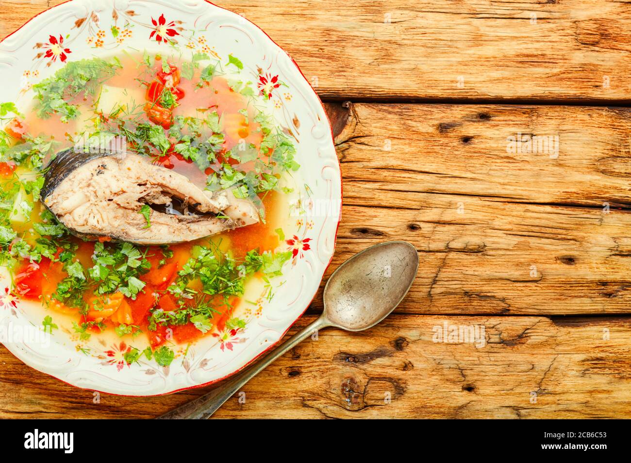 Teller mit Fischsuppe auf einem rustikalen Holztisch.Russische Kosakenfischsuppe Stockfoto