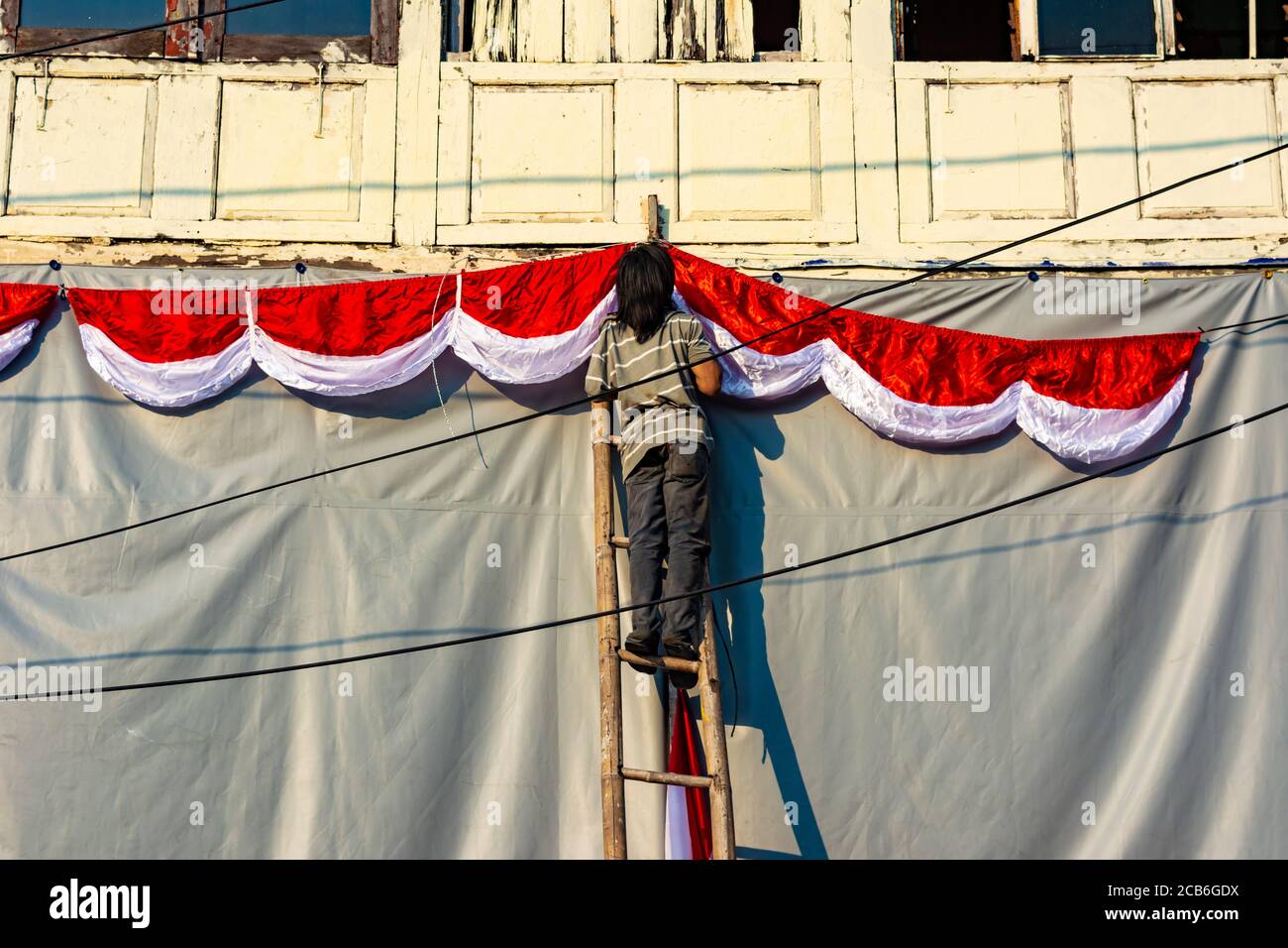 Jemand installiert indonesische Flagge vor einem Gebäude in Kota Tua Jakarta, um den Tag der indonesischen Unabhängigkeit zu feiern Stockfoto