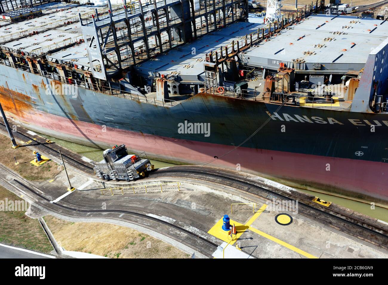 Das Containerschiff Hansa Europe, das durch die Schleuse Miraflores auf dem Panamakanal, Panama, fährt Stockfoto