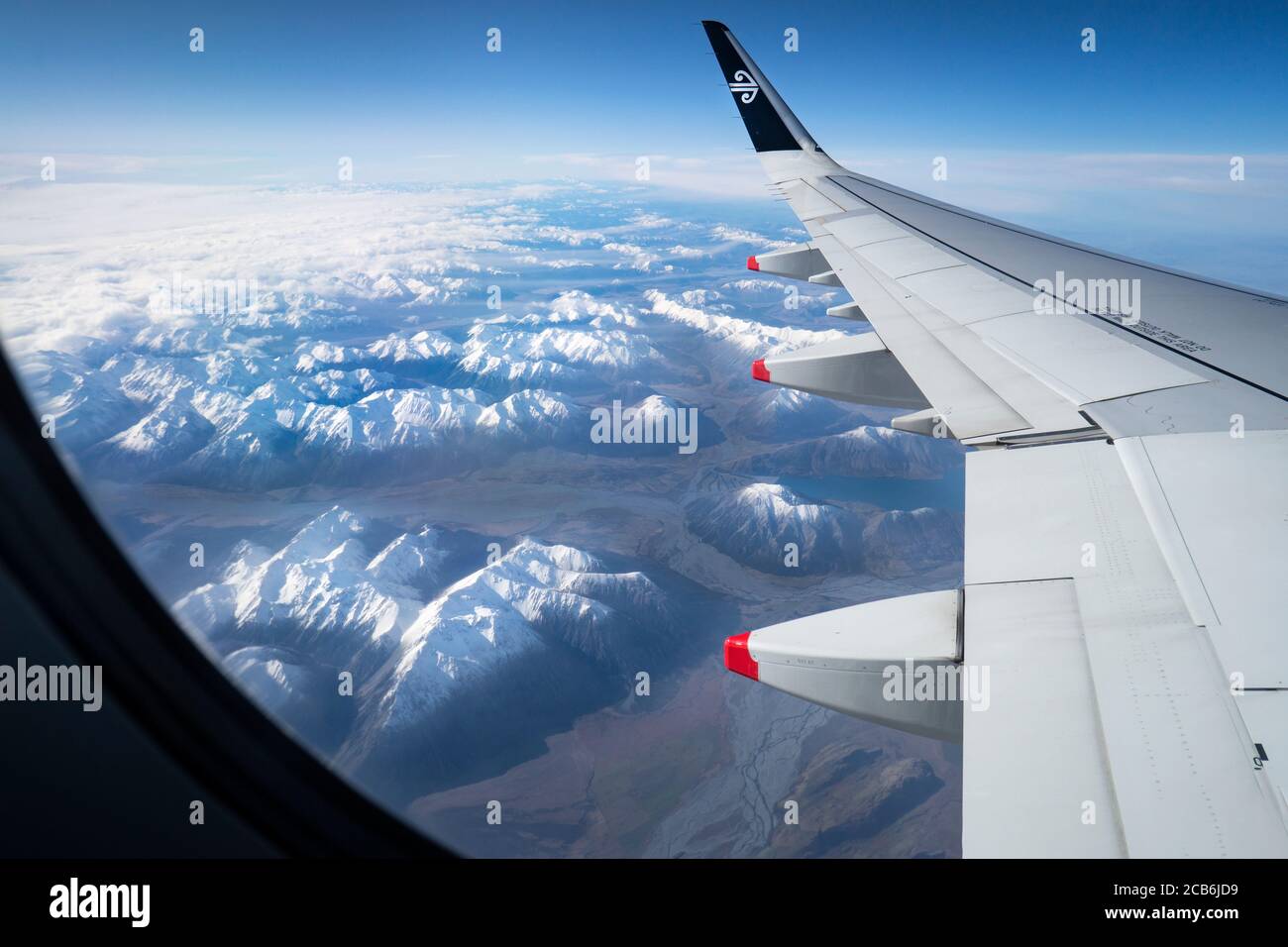 Luftaufnahme eines Flugzeugflügels mit Air New Zealand Logo und den schneebedeckten Bergen und Flüssen im Winter. Bild aufgenommen auf Air NZ Flug fliegen Schlepptau Stockfoto