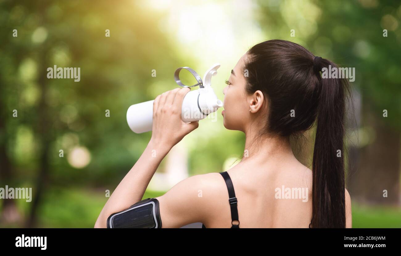 Gesundes Lifestyle-Konzept. Asiatische Jogger Mädchen Trinkwasser, Ruhe nach dem Laufen im Freien Stockfoto