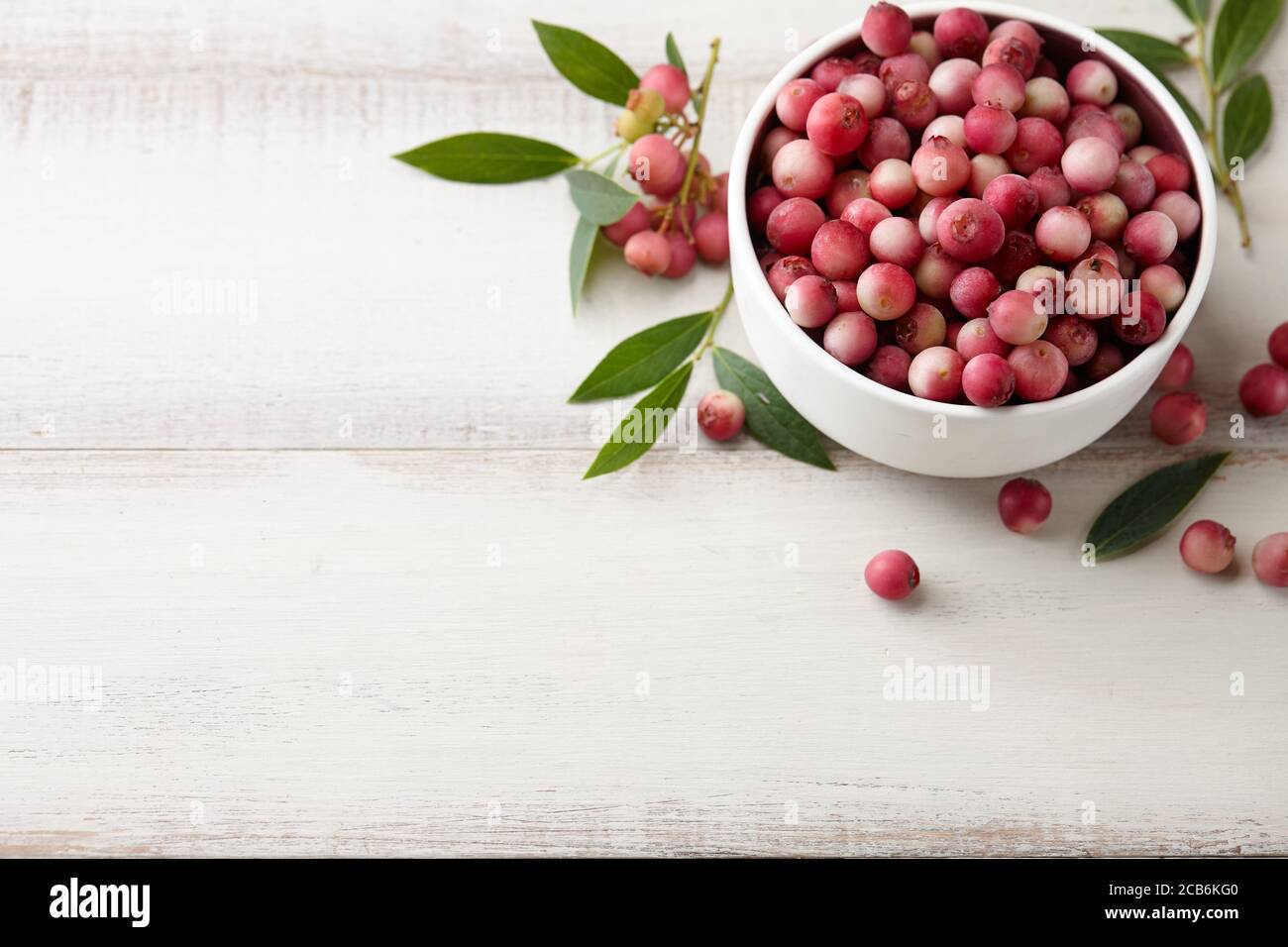 Frische rosa Limonade Heidelbeeren in Schale auf weißem Holztisch Stockfoto
