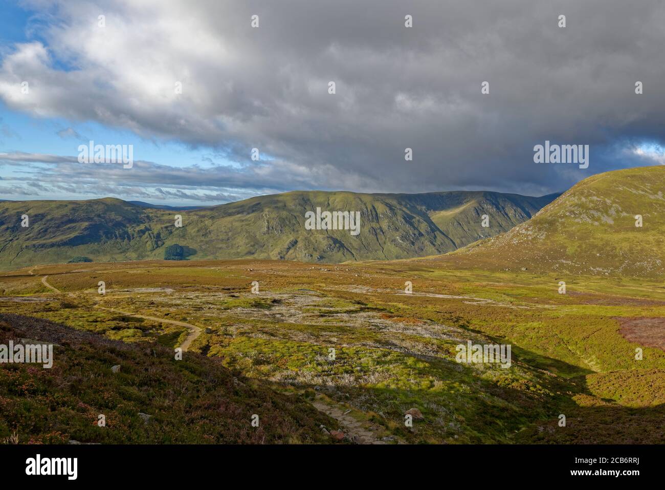 Blick auf den Fußweg zum Loch Brandy von Glen Clova, mit dunklen Wolken beginnen, in der frühen Morgensonne zu bauen. Stockfoto