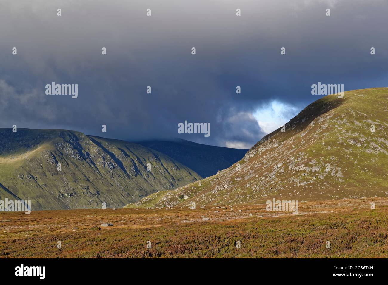 Dunkle Wolken über Glen Clova im Angus Glens, an einem sonnigen Septembermorgen vom Fußweg zum Loch Brandy. Stockfoto