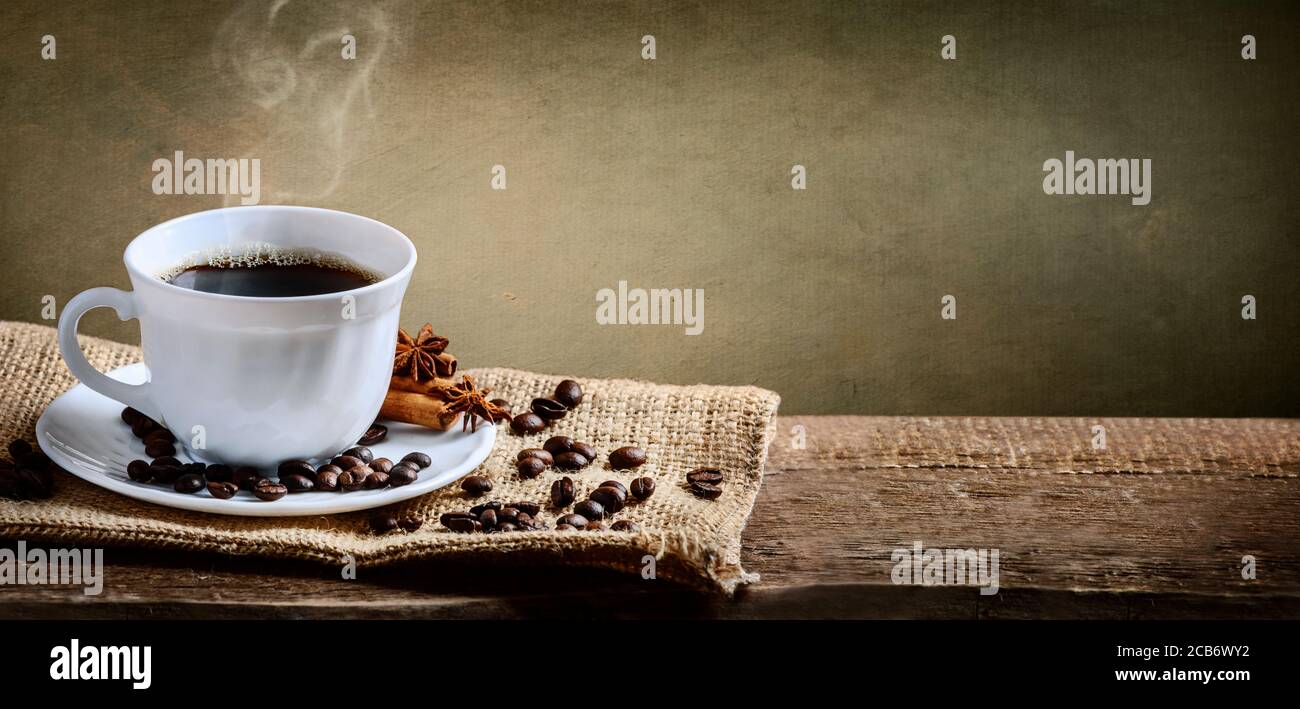 Kaffeetasse, Zimt und Anis auf altem Eistich und rustikalem Holztisch. Banner für heiße Getränke. Vintage Coffee Shop Menü Design Hintergrund. Stockfoto
