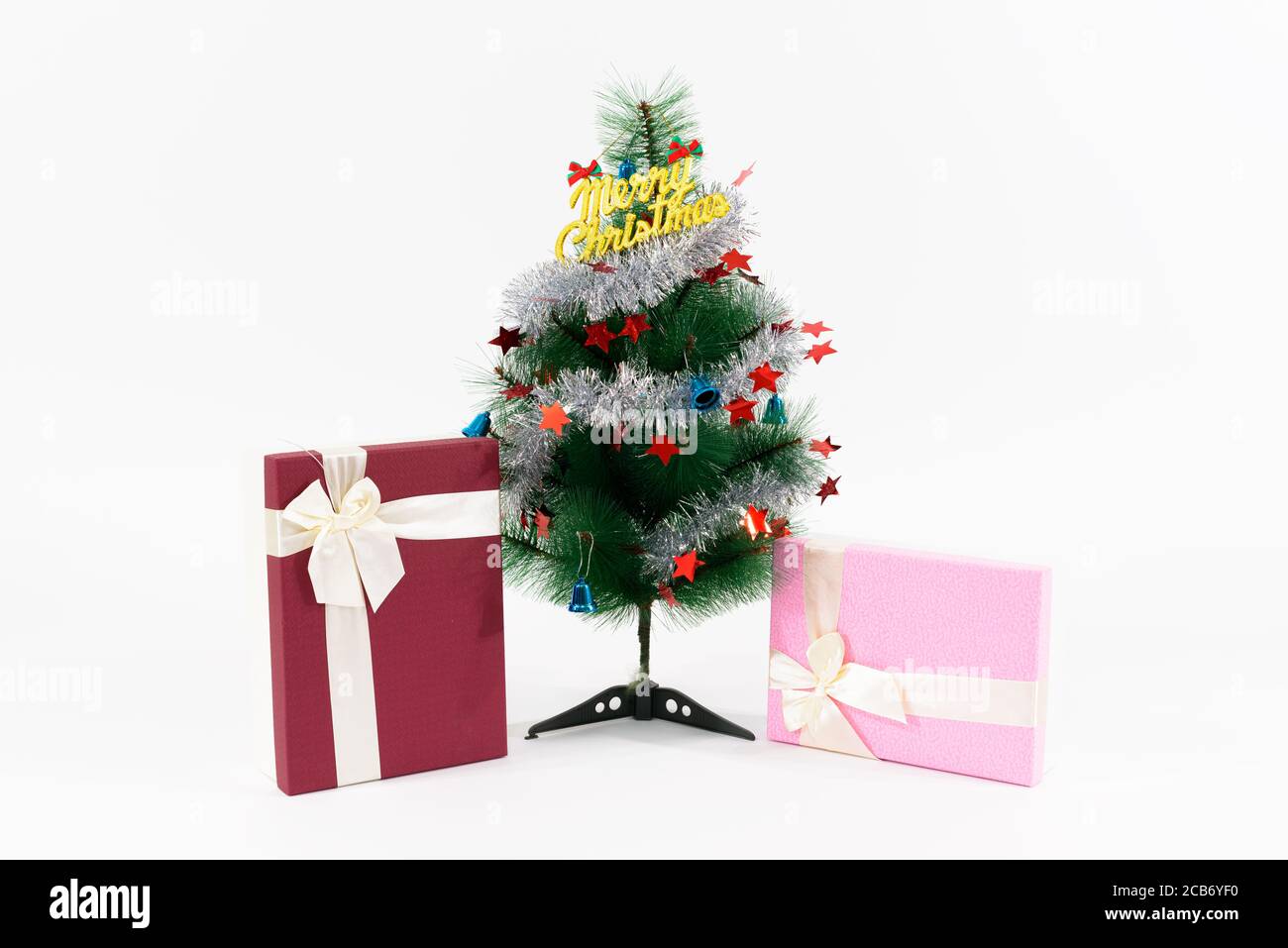 Weihnachtsgeschenke unter geschmückter Weihnachtsbaum mit Frohe Weihnachten Text vor weißem Hintergrund Stockfoto