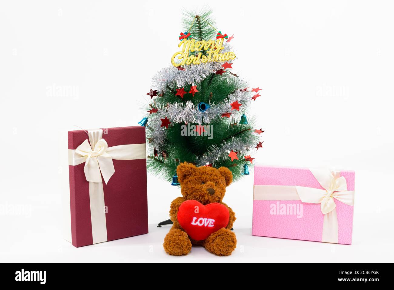 Teddybär mit Liebeszeichen und Weihnachtsgeschenke unter Weihnachten Baum mit fröhlichen Weihnachtsschreiben Stockfoto