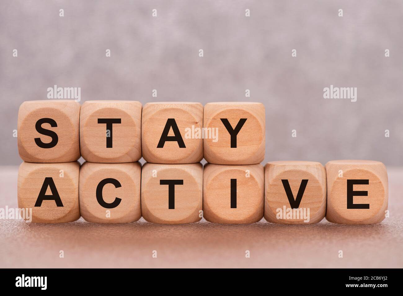 Bleiben Sie aktiv gedruckt auf Holzwürfel Stockfoto