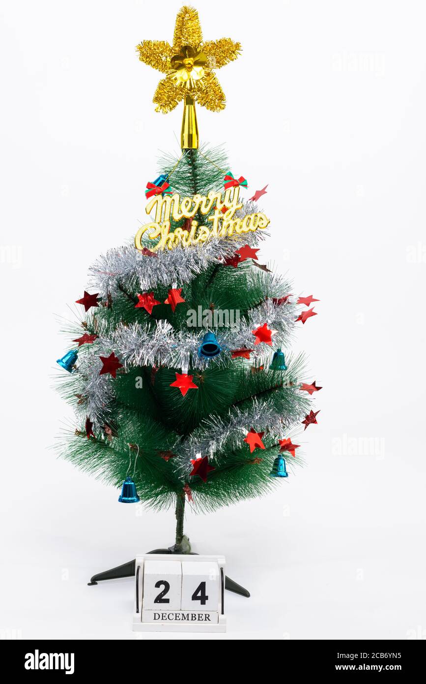 Weihnachtsbaum mit Frohe Weihnachten Text vor weißem Hintergrund mit Kalender schreiben 24 Dezember Stockfoto