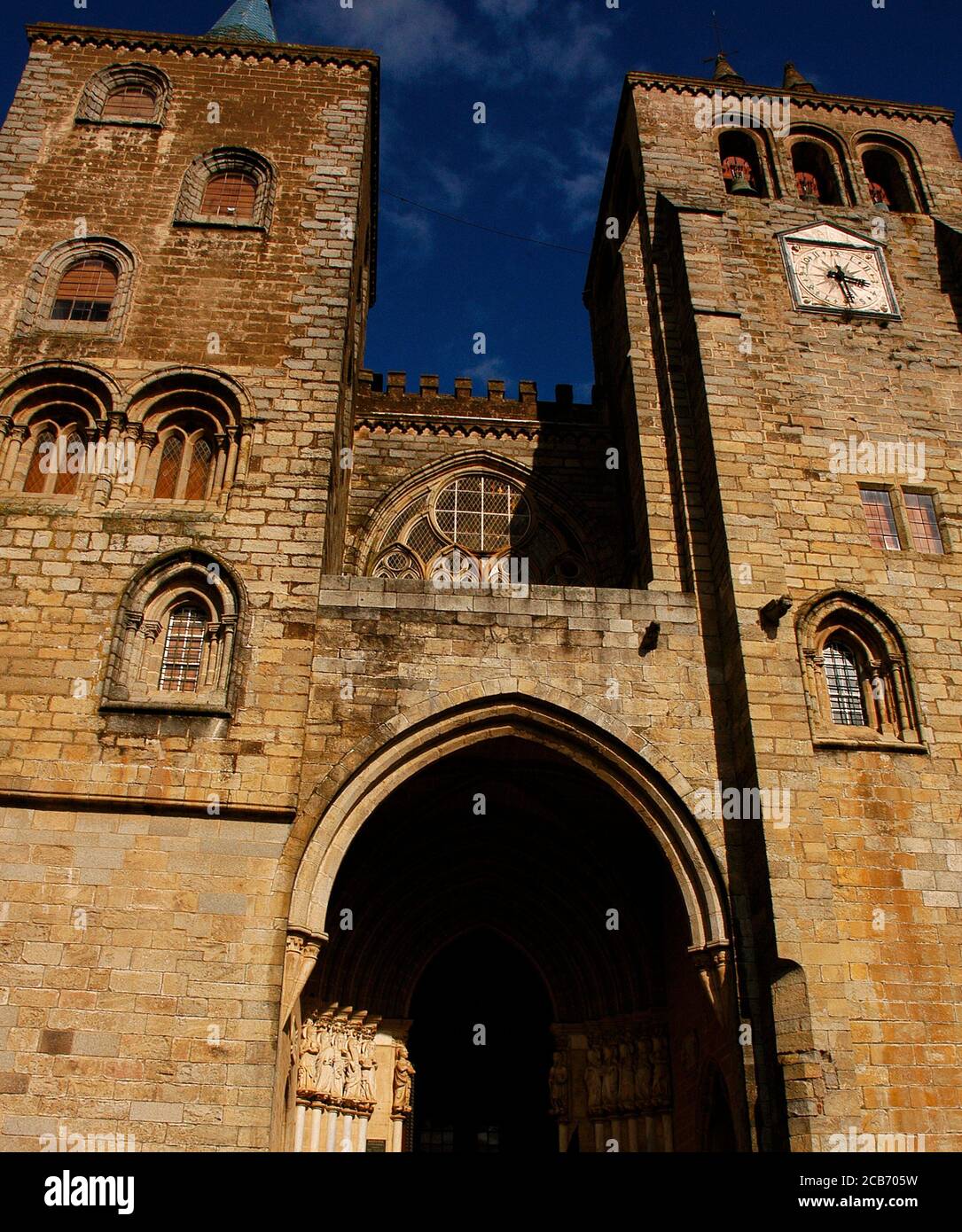 Portugal, Region Alentejo, Evora. Die Kathedrale von Evora (SE de Evora). 1988 von der UNESCO zum Weltkulturerbe erklärt. Hauptfassade. Das Haupteingang Portal, über dem ein gotisches Fenster mit historischen Tracery. Es wird von zwei Türmen flankiert, die im 16. Jahrhundert hinzugefügt wurden. Das gotische Tor ist bemerkenswert für seine gotischen Skulpturen der zwölf Apostel, sechs auf jeder Seite des Eingangs, die im frühen 14. Jahrhundert hinzugefügt wurden. Stockfoto