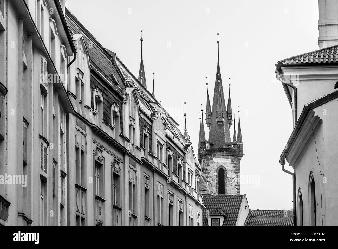 Zwei Türme der Kirche unserer Lieben Frau vor Tyn teilweise hinter alten Stadtgebäuden versteckt, Prag, Tschechische Republik. Schwarzweiß-Bild. Stockfoto