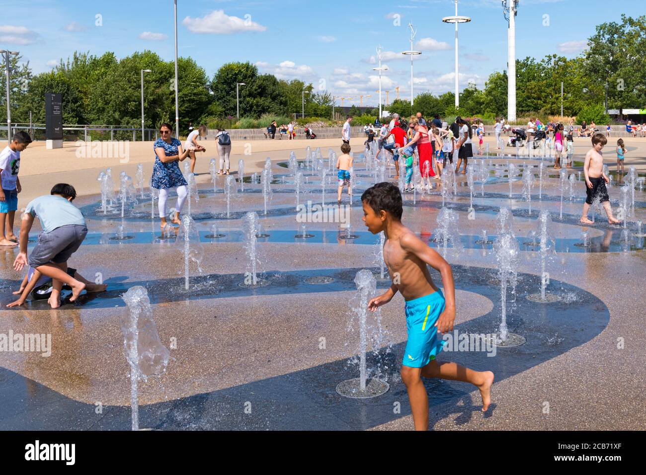 England London Stratford Hackney Wick Queen Elizabeth Park Lee Valley Kinder Kinder Spielbereich Wasserspiel Brunnen Unterhaltung spielen laufen Spaß Stockfoto