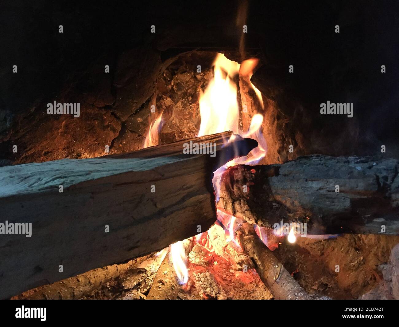 Traditionelle Art der Herstellung von Lebensmitteln durch die Verwendung von Holz als Bio-Brennstoff auf offenem Feuer in der alten Küche in einem Dorf. Ländliche Küche mit Bio-Holz Brennstoff zum Kochen. Stockfoto