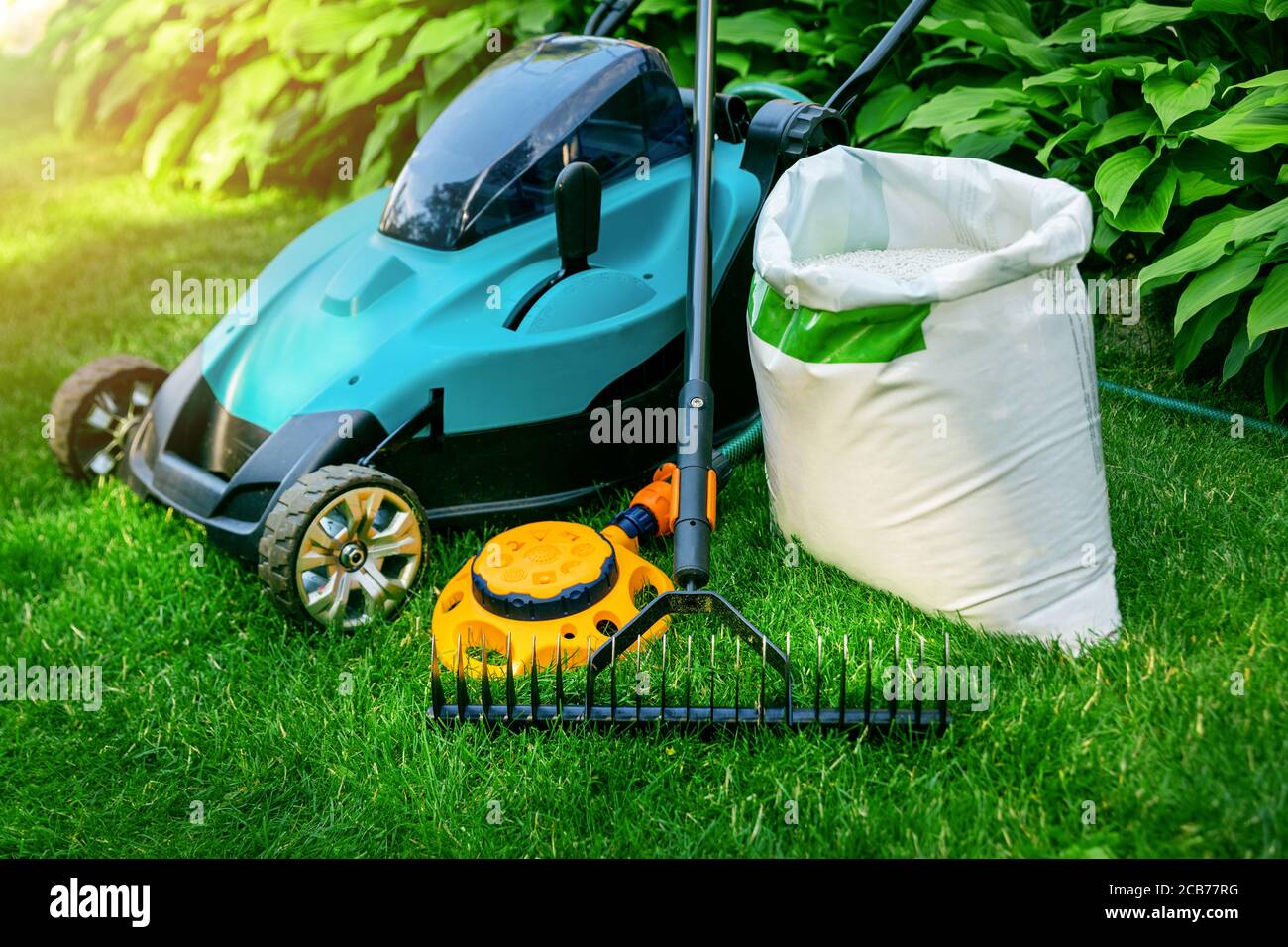 Gartengeräte und Rasenpflegegeräte auf grünem Gras Stockfoto