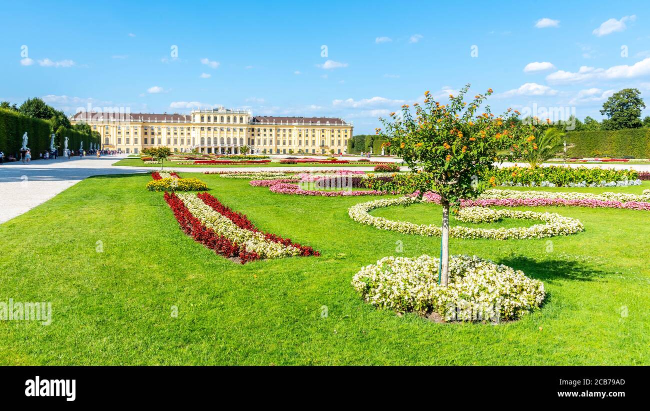 WIEN, ÖSTERREICH - 23. JULI 2019: Schloss Schönbrunn, Deutsch: Schloss Schönbrunn, und großer Parterre - Französischer Garten mit schönen Blumenbeeten, Wien, Österreich Stockfoto