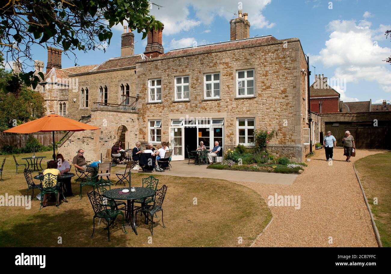 Besucher genießen Erfrischungen vor dem Almonry Restaurant auf dem Gelände der Ely Cathedral, Ely, Cambridgeshire, England. Stockfoto