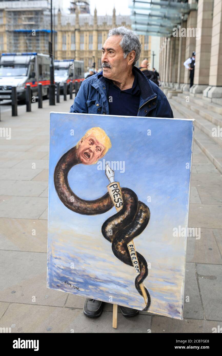 Künstler und politischer Satiriker Kaya Mar mit einem Gemälde über Pressefreiheit während Donald Trumps Besuch, Westminster, London, Großbritannien Stockfoto