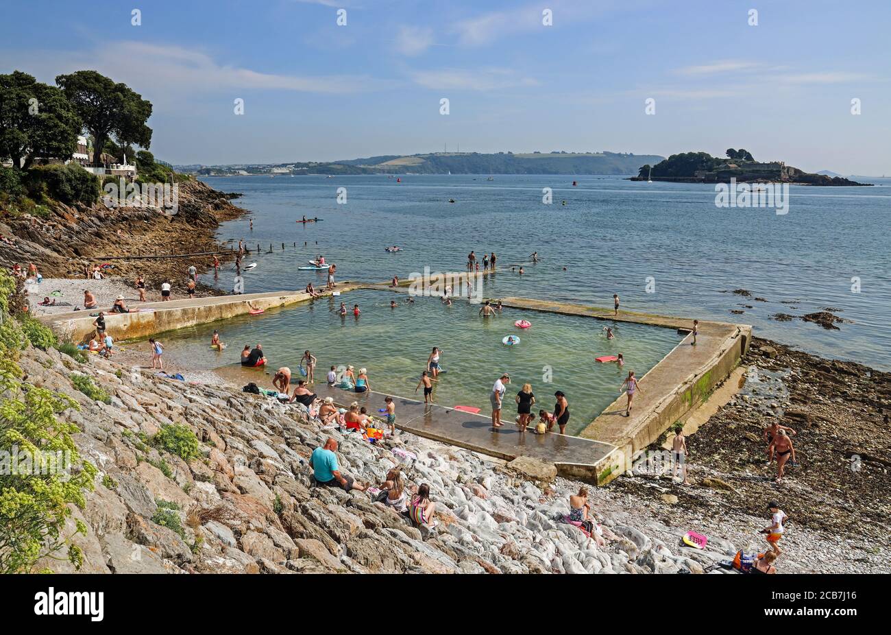 Badegäste genießen an einem heißen Sommertag an der Strandpromenade in Stonehouse, Plymouth, den Außenpool am Devil’s Point AKA Western Kings. Ein Meerwasser Stockfoto