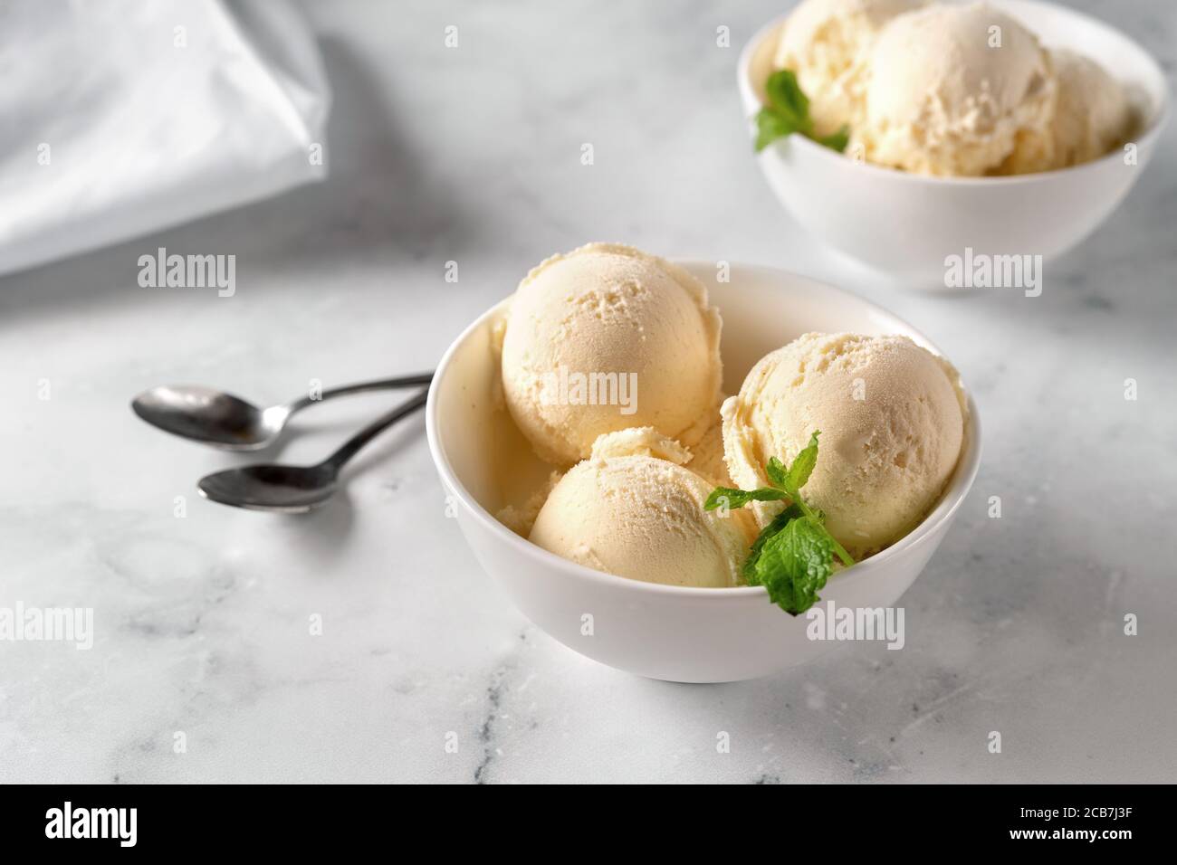 Vanilleeis in zwei Tellern auf weißem Hintergrund Stockfoto