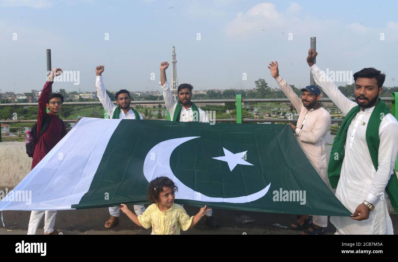 Lahore, Pakistan. August 2020. Pakistanische Jugendliche halten Nationalflagge und rufen Slogan gegen Greater Iqbal Park Verwaltung in Azadi Inter-Change in Lahore. Als Regierung wieder Parks, öffentliche Plätze, Schreine, Basare, Märkte, Restaurants im ganzen Land, die während der Corona-Virus Ausbruch geschlossen wurden, während Greater Iqbal Park Verwaltung sagte, dass sie jede offizielle Benachrichtigung über die Wiedereröffnung des Parks in Provinzhauptstadt erhalten. (Foto von Rana Sajid Hussain/Pacific Press) Quelle: Pacific Press Media Production Corp./Alamy Live News Stockfoto