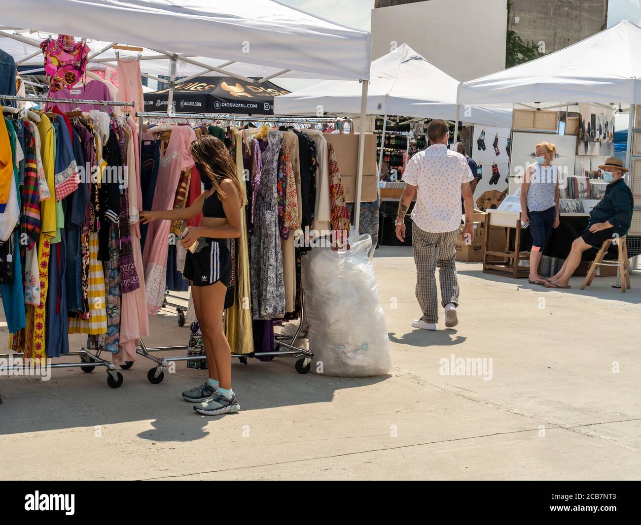 Am Eröffnungstag, Sonntag, 9. August 2020, erdulden die Käufer die Hitze auf dem Greenpoint Terminal Market. Der Markt behielt die extrabreiten Gänge aufrecht, eine Voraussetzung für Gesichtsbedeckung und soziale Distanzierungsprotokolle, da Käufer handwerkliche und antike Waren sowie eine Auswahl von Lebensmittelhändlern durchstöberten. (© Richard B. Levine) Stockfoto