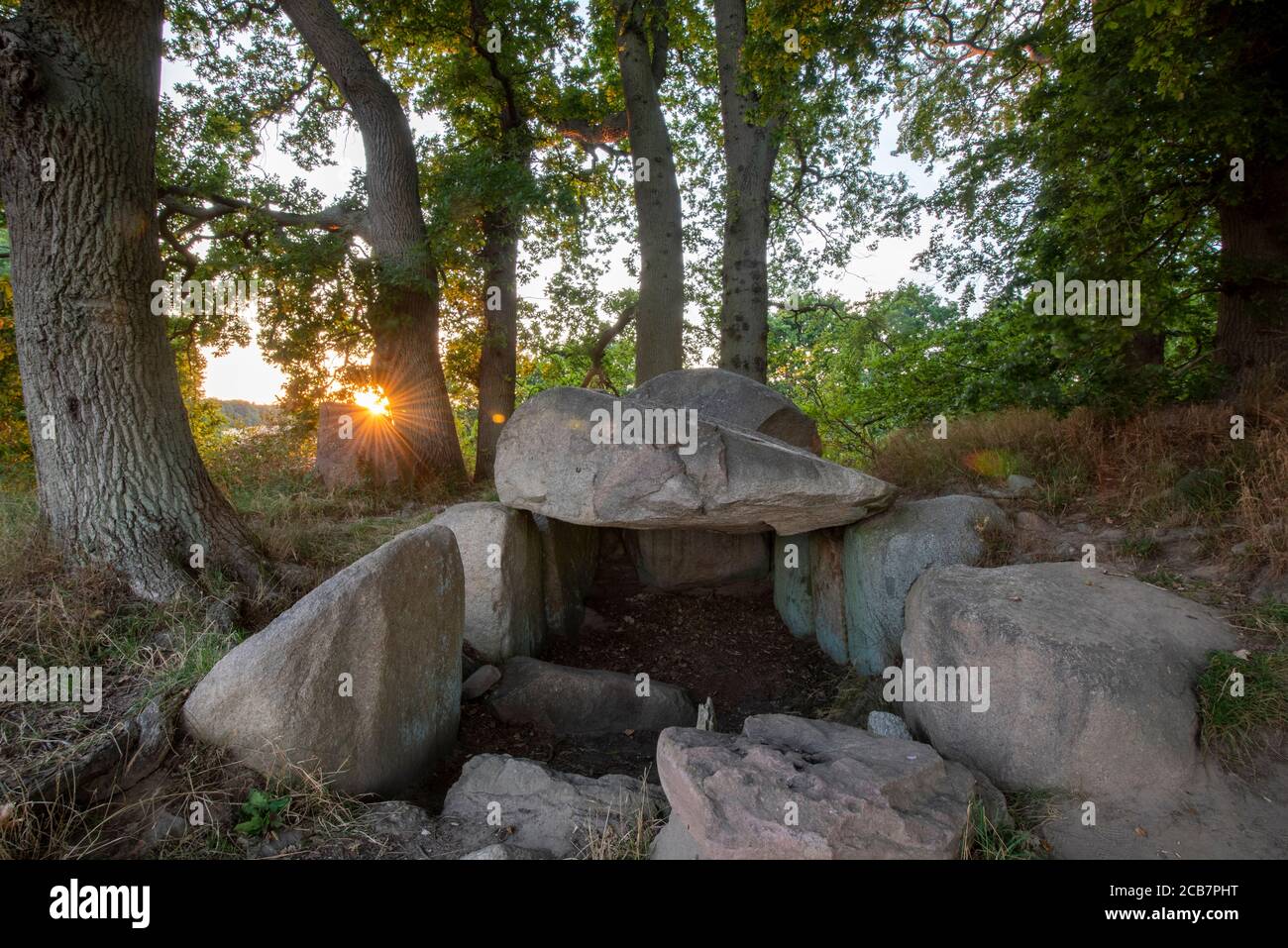 Lancken Granitz, Deutschland. August 2020. Die Sonne untergeht hinter einem megalithischen Grab. Die Megalithgräber bei Lancken-Granitz auf der Insel Rügen sind acht Gräber der neolithischen Trichterbecherkultur. Quelle: Stephan Schulz/dpa-Zentralbild/ZB/dpa/Alamy Live News Stockfoto