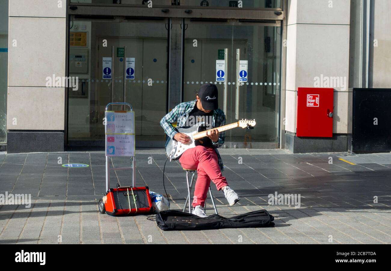 Ein Straßenmusiker, der die E-Gitarre in einer leeren High Street in Liverpool, City Centre, England spielt Stockfoto