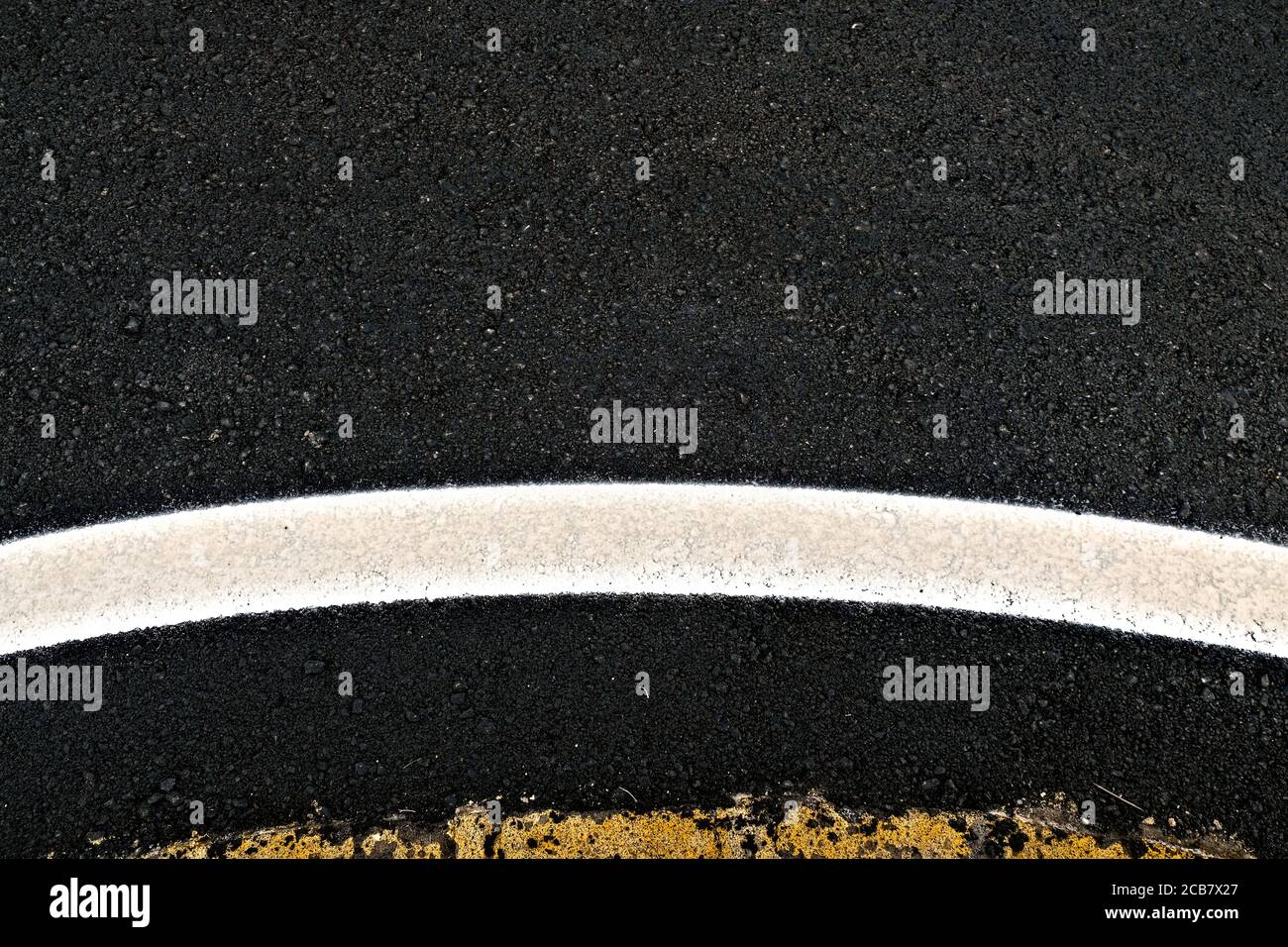 Breite geschwungene reflektierende Band an einem Kreisverkehr, ein abstraktes Straßendetail. Stockfoto