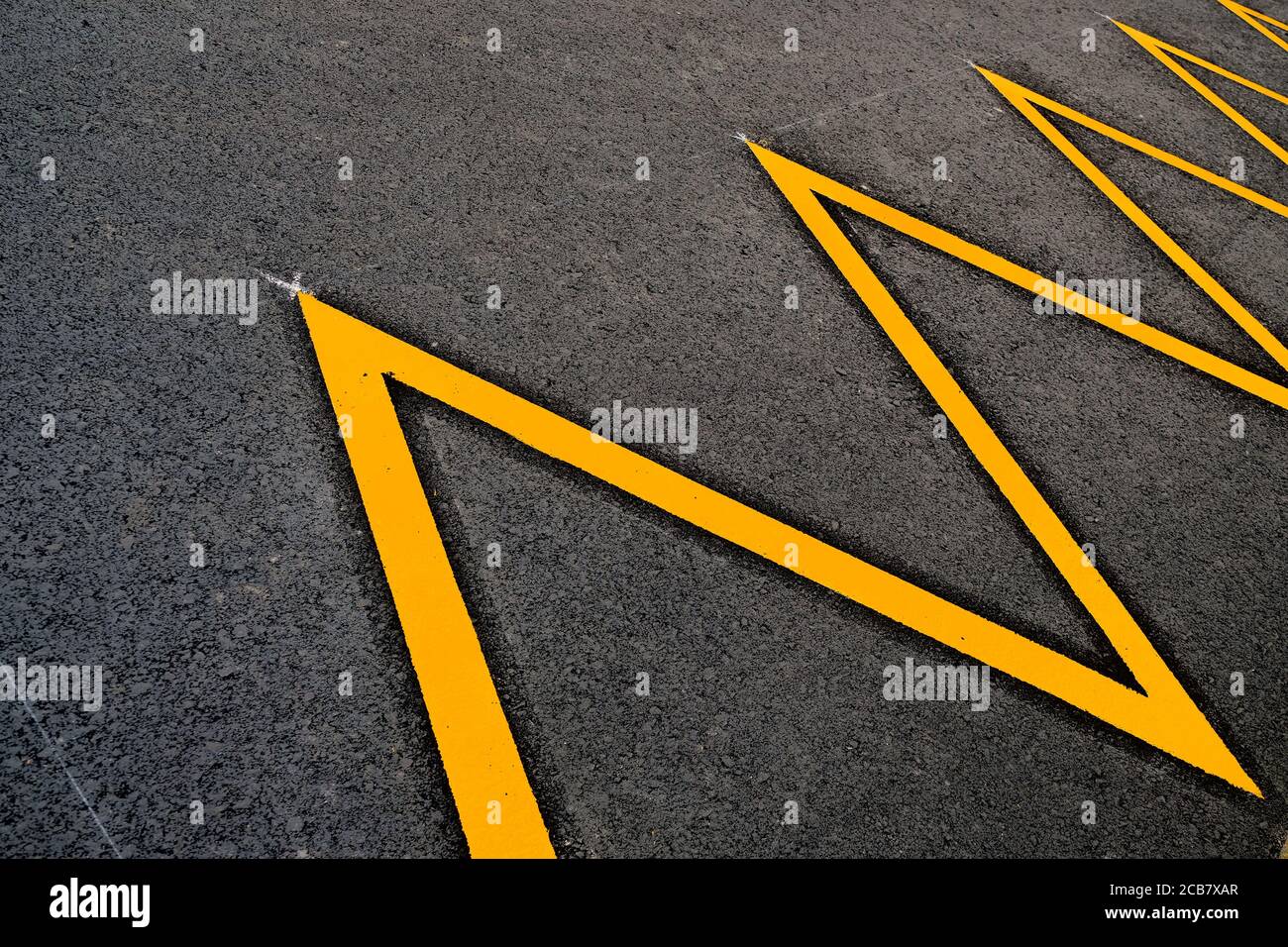 Ein abstraktes Zick-Zack-Detail des Parkplatzes in gelb reflektierende Farbe markiert. Stockfoto
