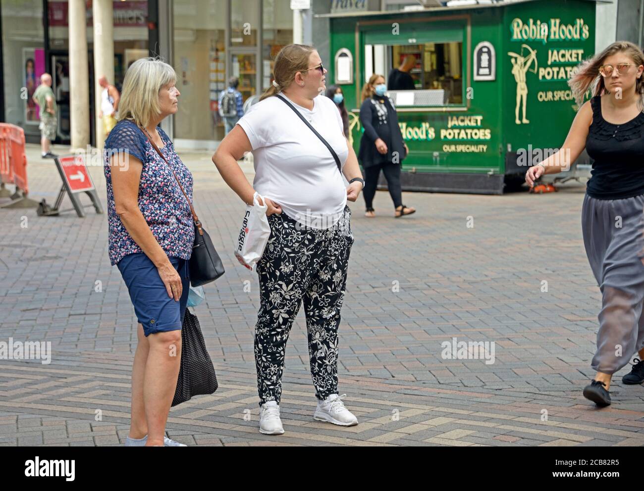 Übergewichtige Dame wartet auf der Straße Stockfoto