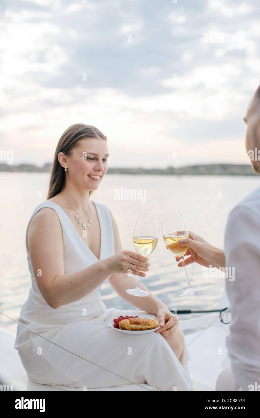 Lächelndes Paar sitzt auf einer Yacht toasting mit einem Glas Weißwein, Russland Stockfoto
