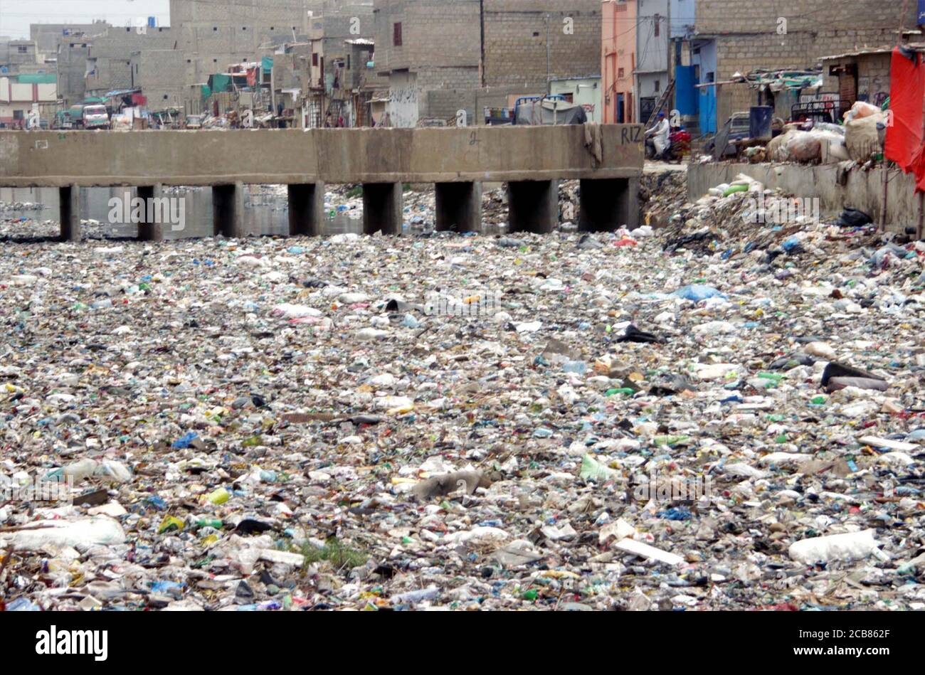 Ein Blick auf den offenen Abfluss, der sich mit Polyethylen-Säcken, Büschen und Müll füllt, wodurch eine unhygienische Atmosphäre entsteht, was Nachlässigkeit der betroffenen Behörden zeigt, die sich am Dienstag, 11. August 2020 im Gebiet von Mehmoodabad in Karachi befinden. Stockfoto