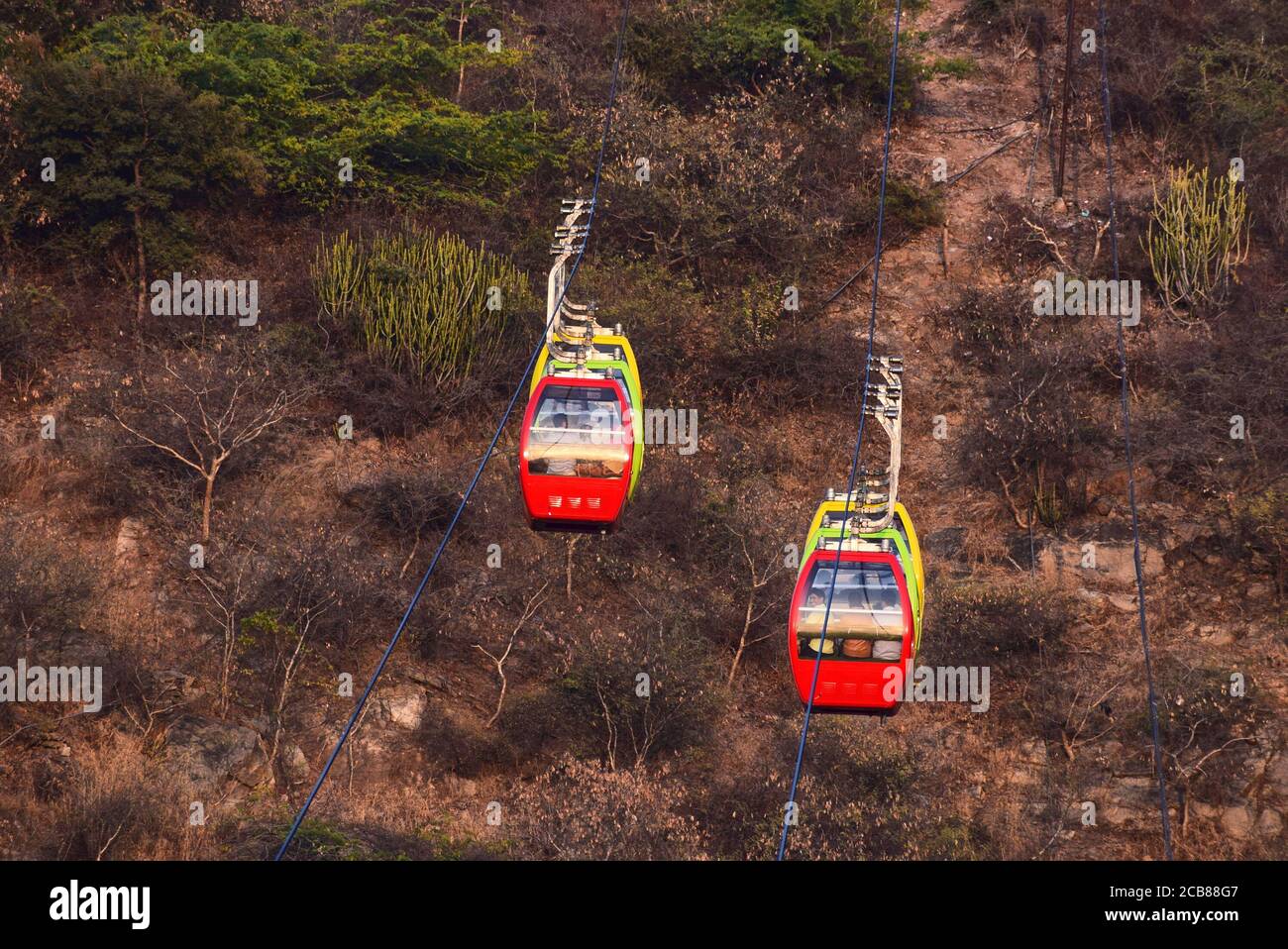 Ein Seilbahnwagen trägt die Anhänger der Göttin Mansapurna Karni Mata in Udaipur von einem Ende zum anderen - Udaipur, Rajasthan, Indien Stockfoto