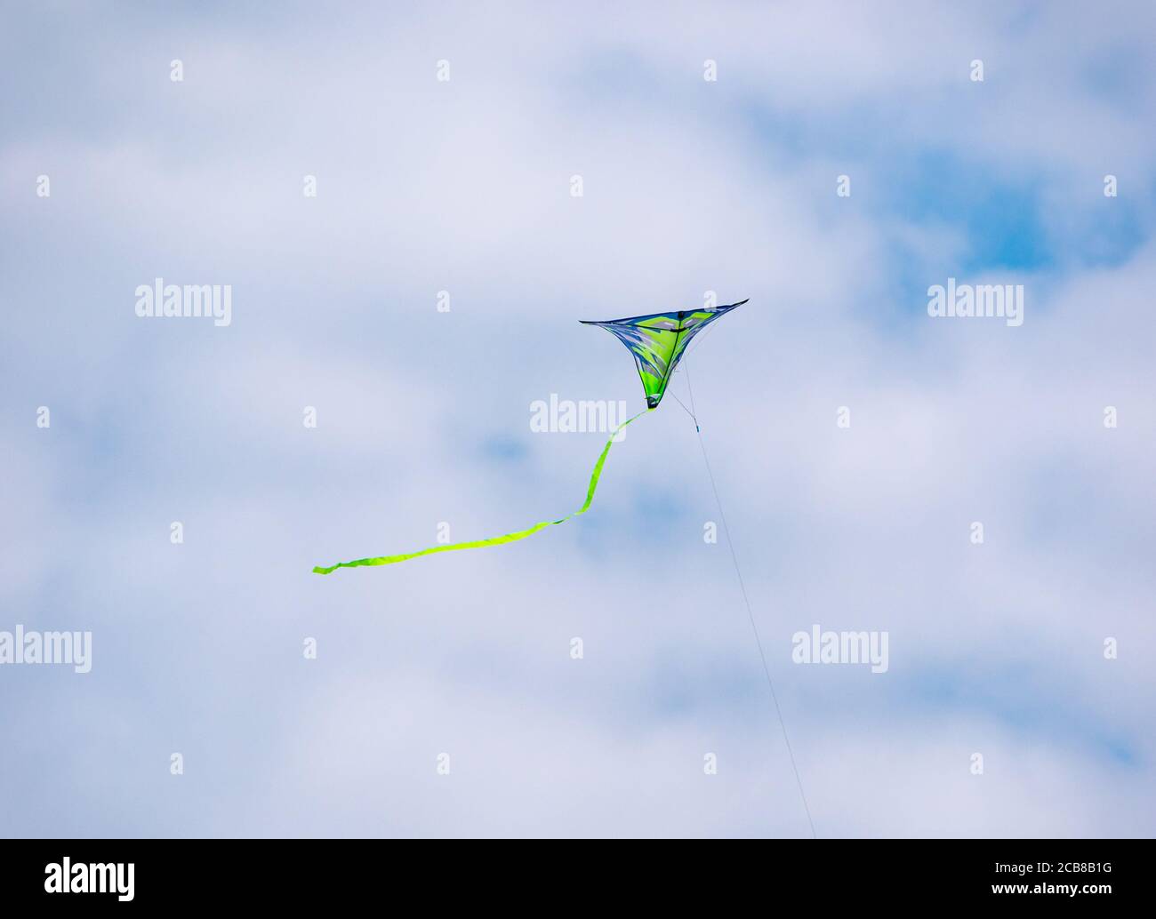 Bunte Drachen fliegen hoch in einem sonnigen Himmel mit Weiß Wolken Stockfoto