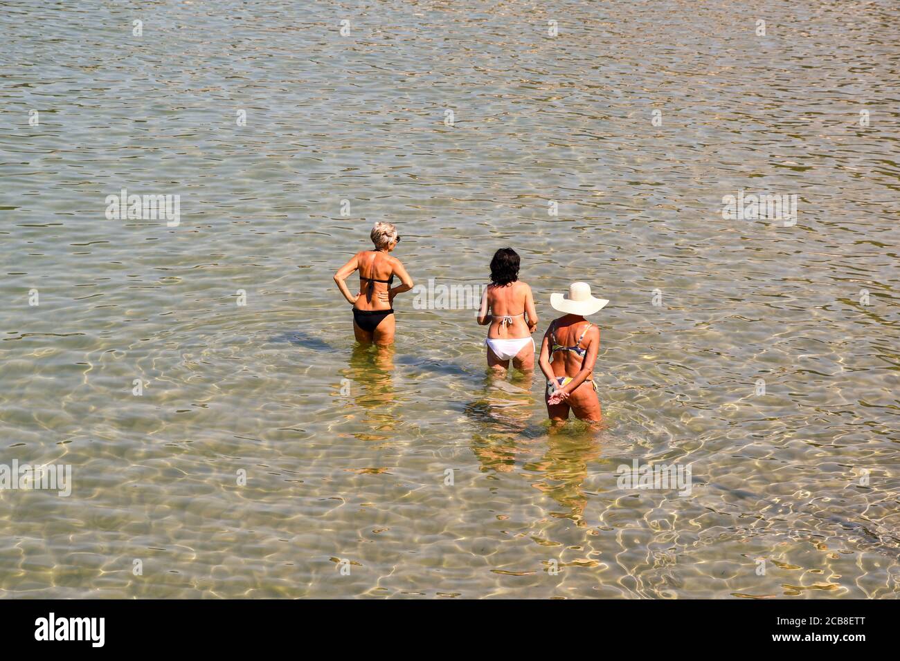 High-Angle-Ansicht von drei Frauen von hinten erfrischend im Wasser der Küste im Sommer, Ligurien, Italien Stockfoto
