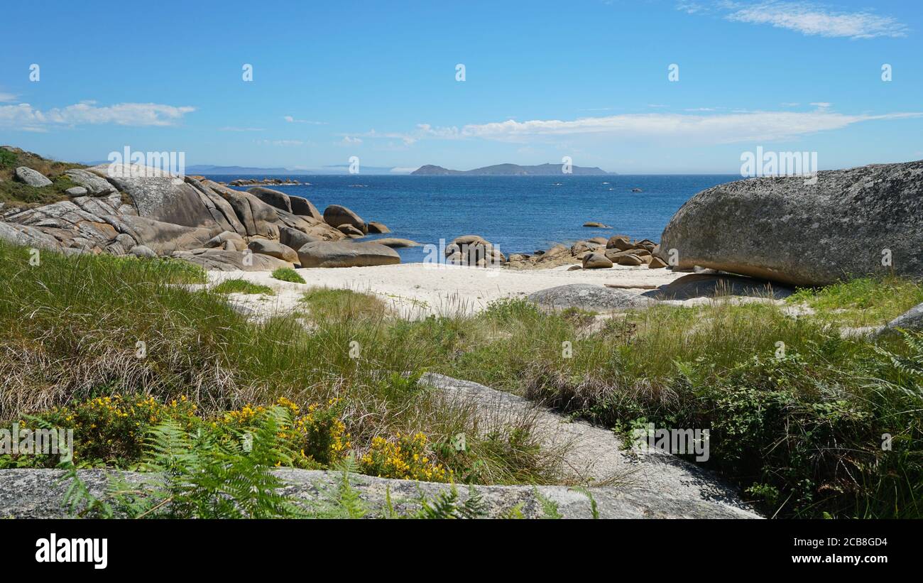 Spanien, Galizien, Sandstrand mit Granitfelsen und die Insel Ons im Hintergrund, Atlantik, Provinz Pontevedra, San Vicente do Grove Stockfoto