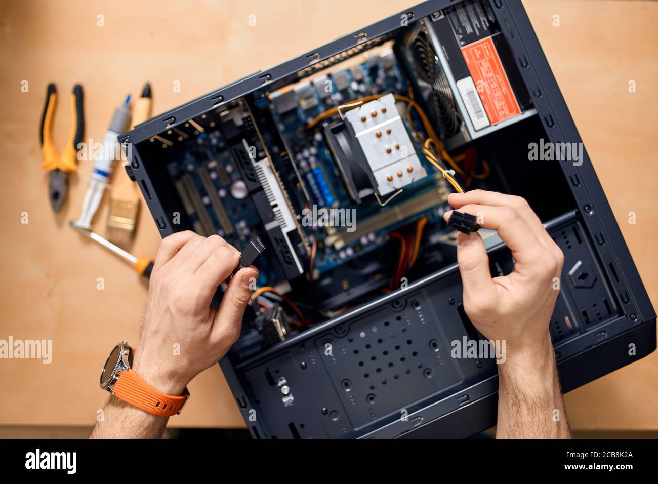Reparaturman zerlegt einen Computer, Draufsicht Foto Stockfoto