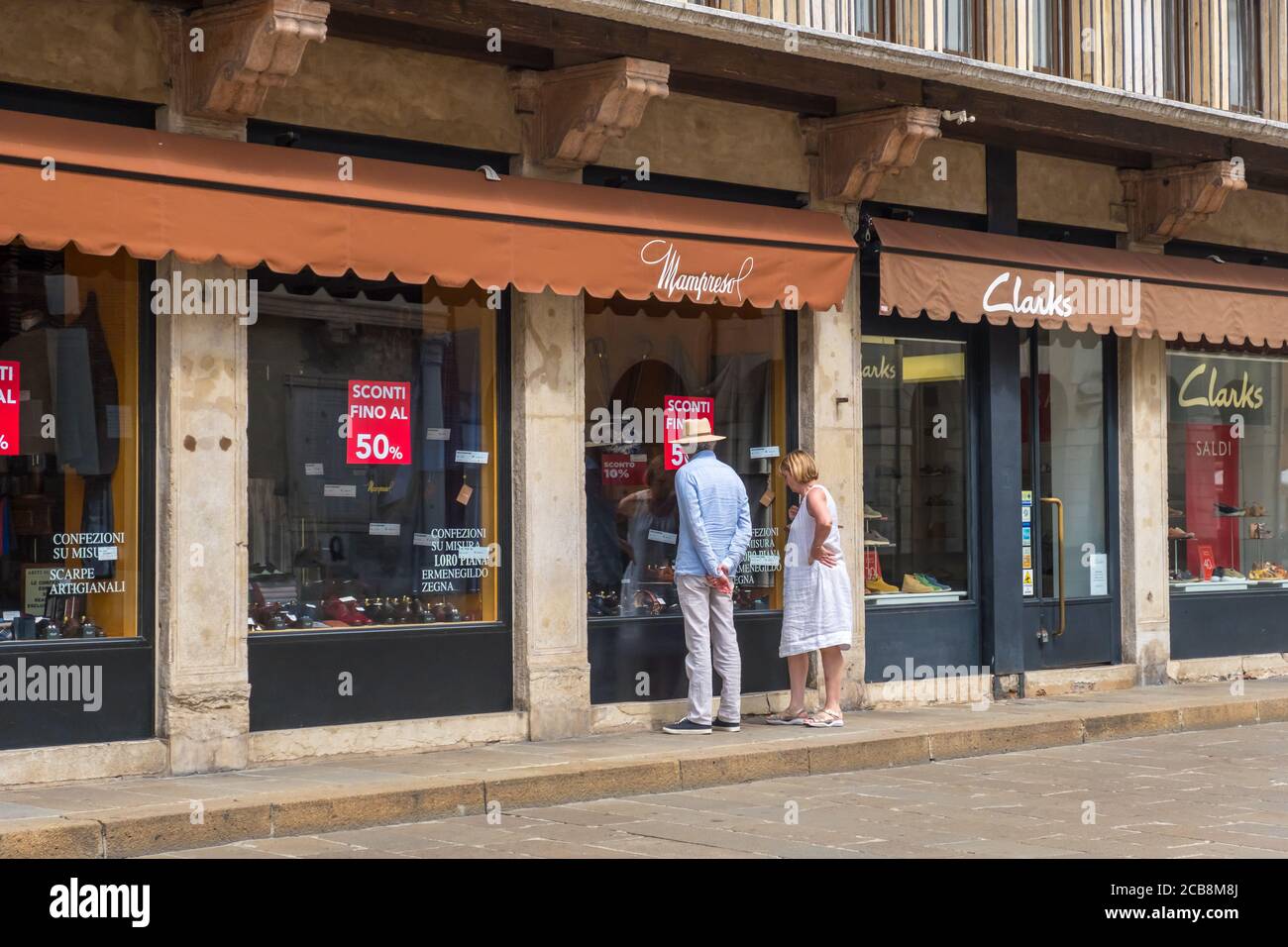 Vicenza, Italien - 12. August 2019: Ein Mann und eine Frau blicken auf ein Schaufenster auf der Piazza dei Signori in Vicenza, Region Venetien Stockfoto