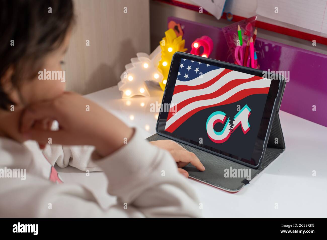 Antalya, TÜRKEI - 07. August 2020. Tablet mit amerikanischer Flagge und gebrochenem tiktok-Logo auf dunklem Hintergrund Stockfoto